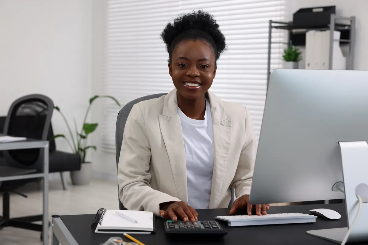 Smiling professional woman working at a computer in a bright office
