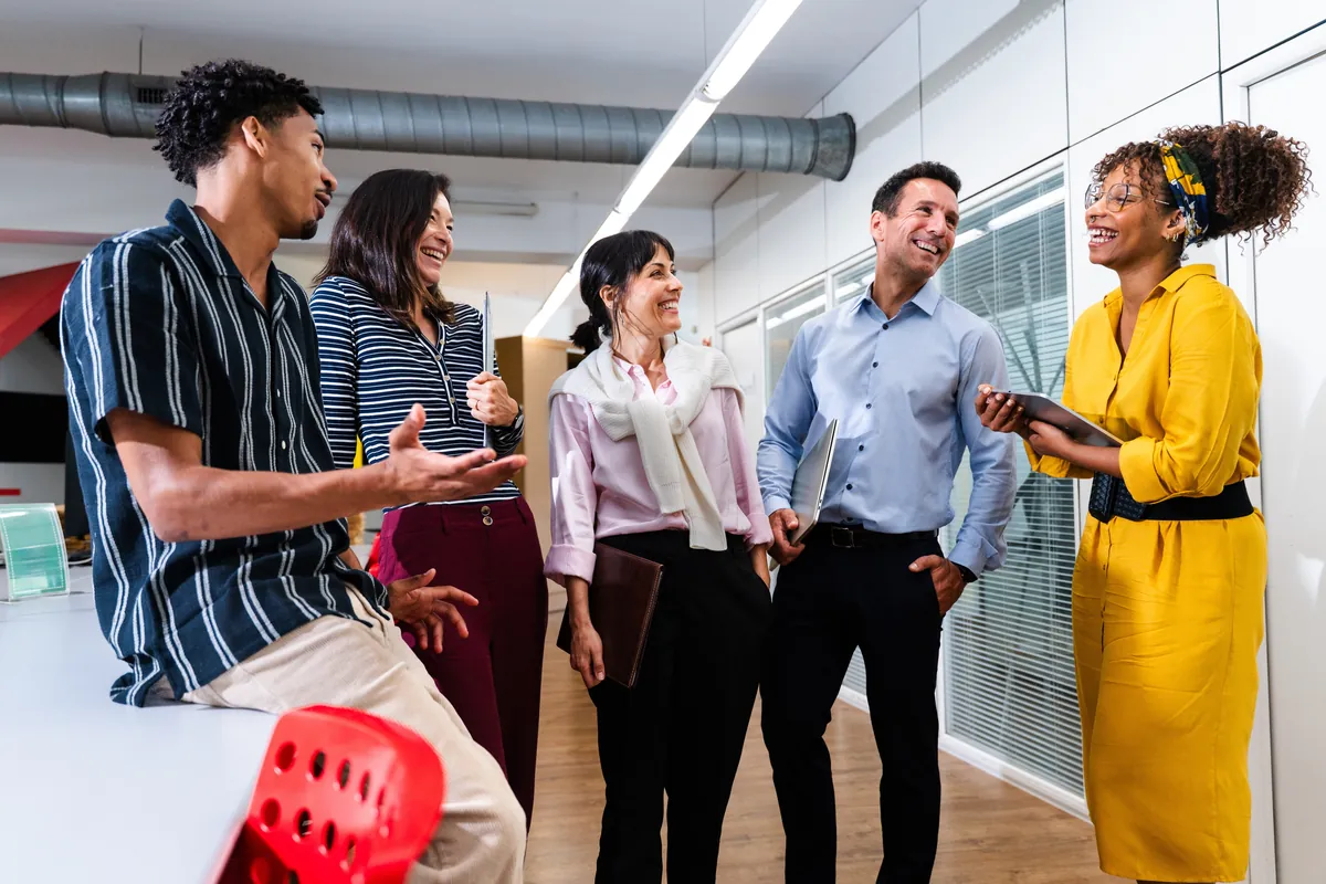 Diverse team chatting together in a bright open co-working space