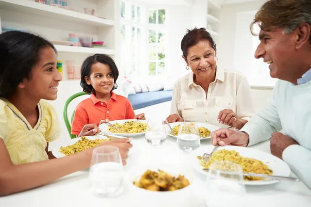 Grandparents sharing a meal with grandchildren at home