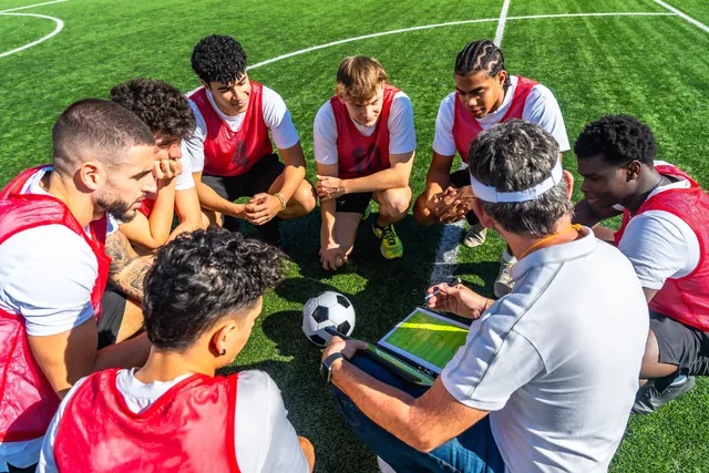 Coach briefing a diverse sports team at training