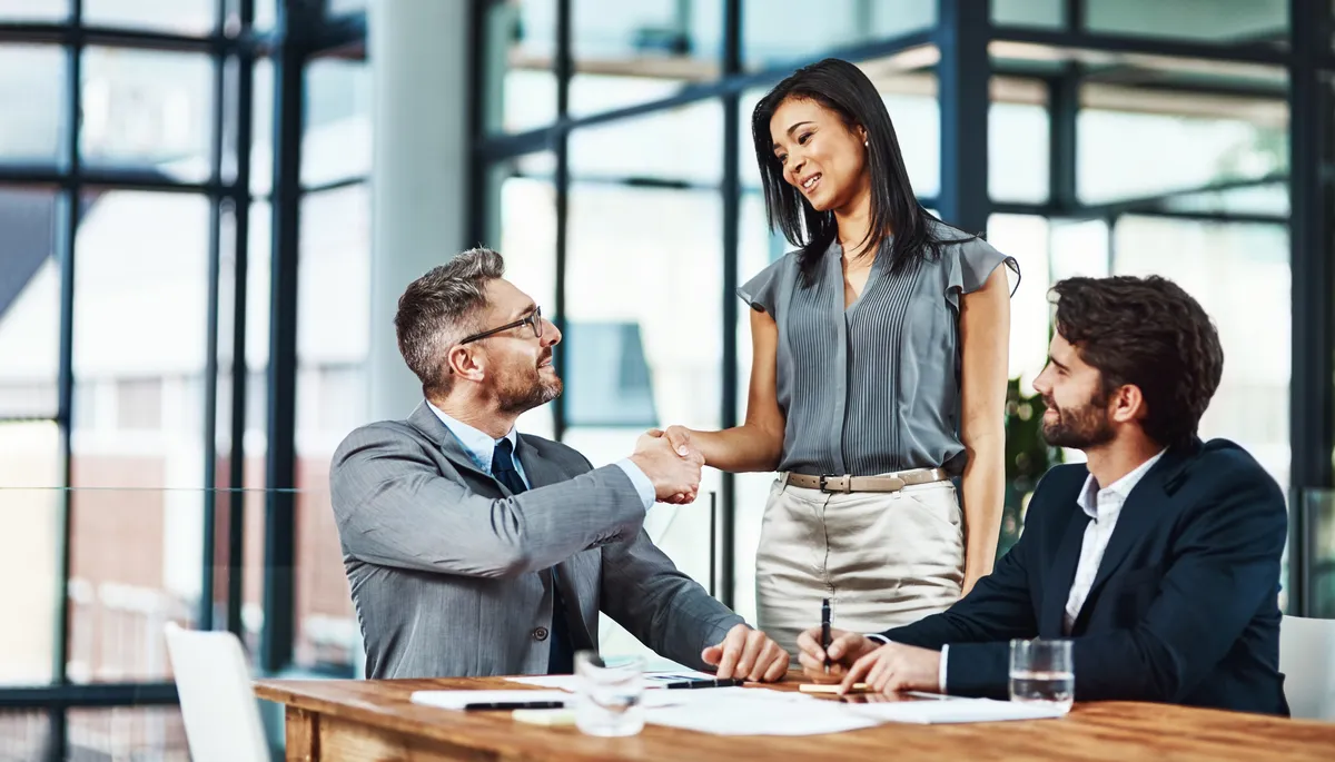 Business partners shaking hands in a bright office