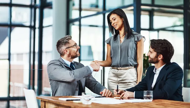 Business partners shaking hands in a bright office