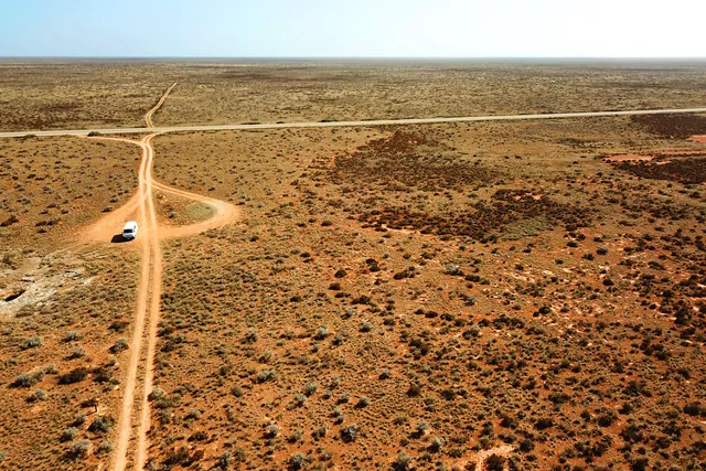 Aerial view of a dirt road crossing the red outback